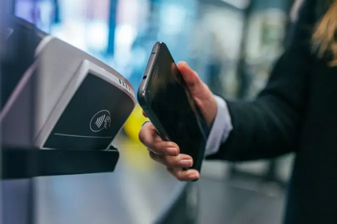 Image of a person using a phone fr contactless payment