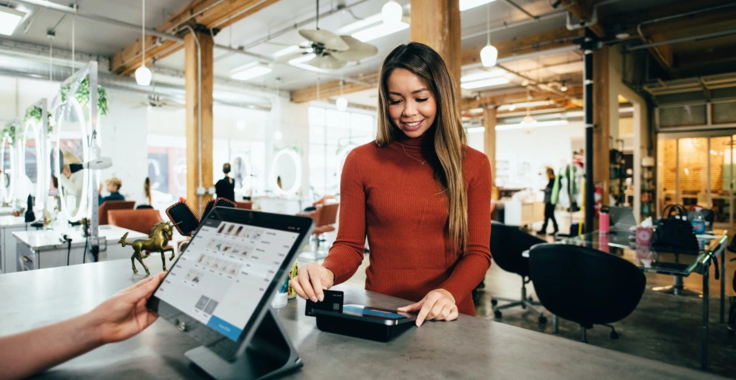 Image of a woman in a store making a quick and seamless payment using Erply's software