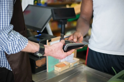 Image of a payment transaction happening in a store using a card terminal